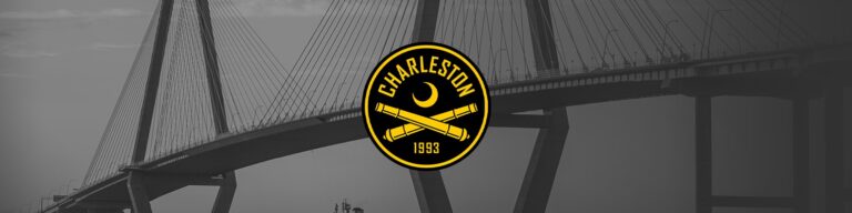 Black-and-white bridge backdrop with a bold yellow Charleston 1993 logo centered, featuring a crescent and two crossed cannons beneath it.