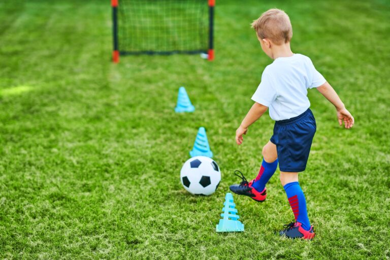 Little Boy practising soccer outdoors