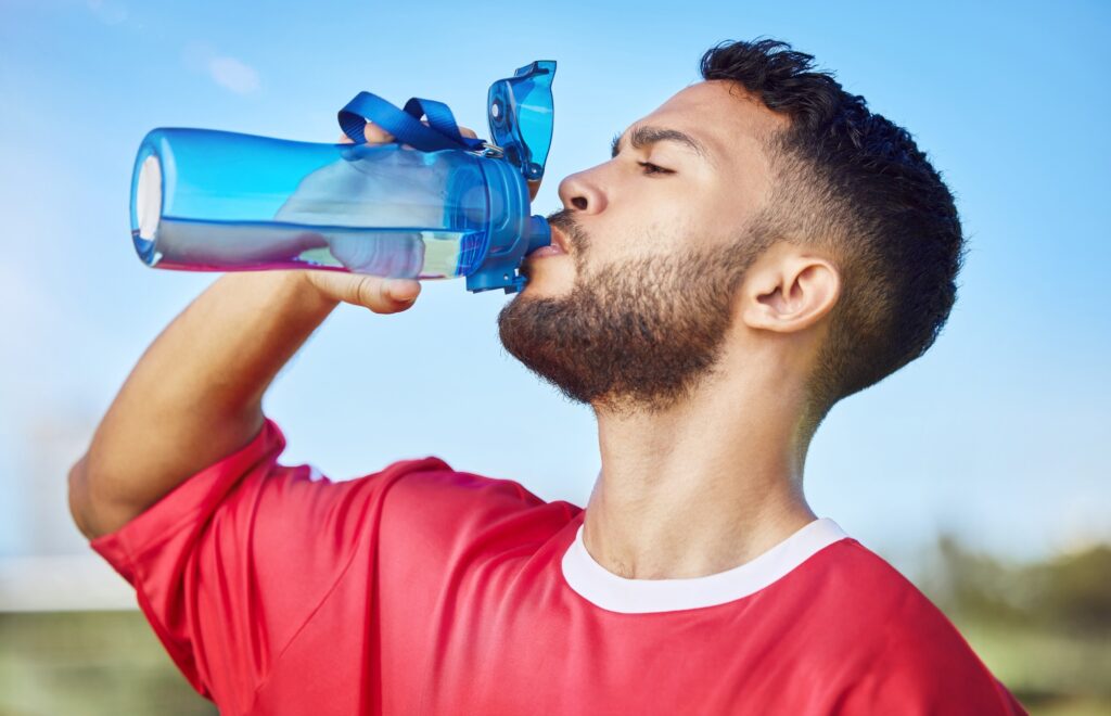 Man, soccer and hydration drinking water for sports motivation, fitness and exercise in the outdoor