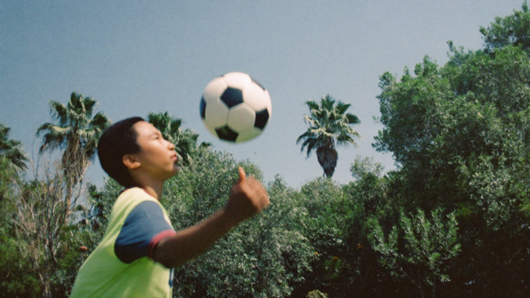 Young soccer player juggling a ball in a backyard over summer break in coastal South Carolina