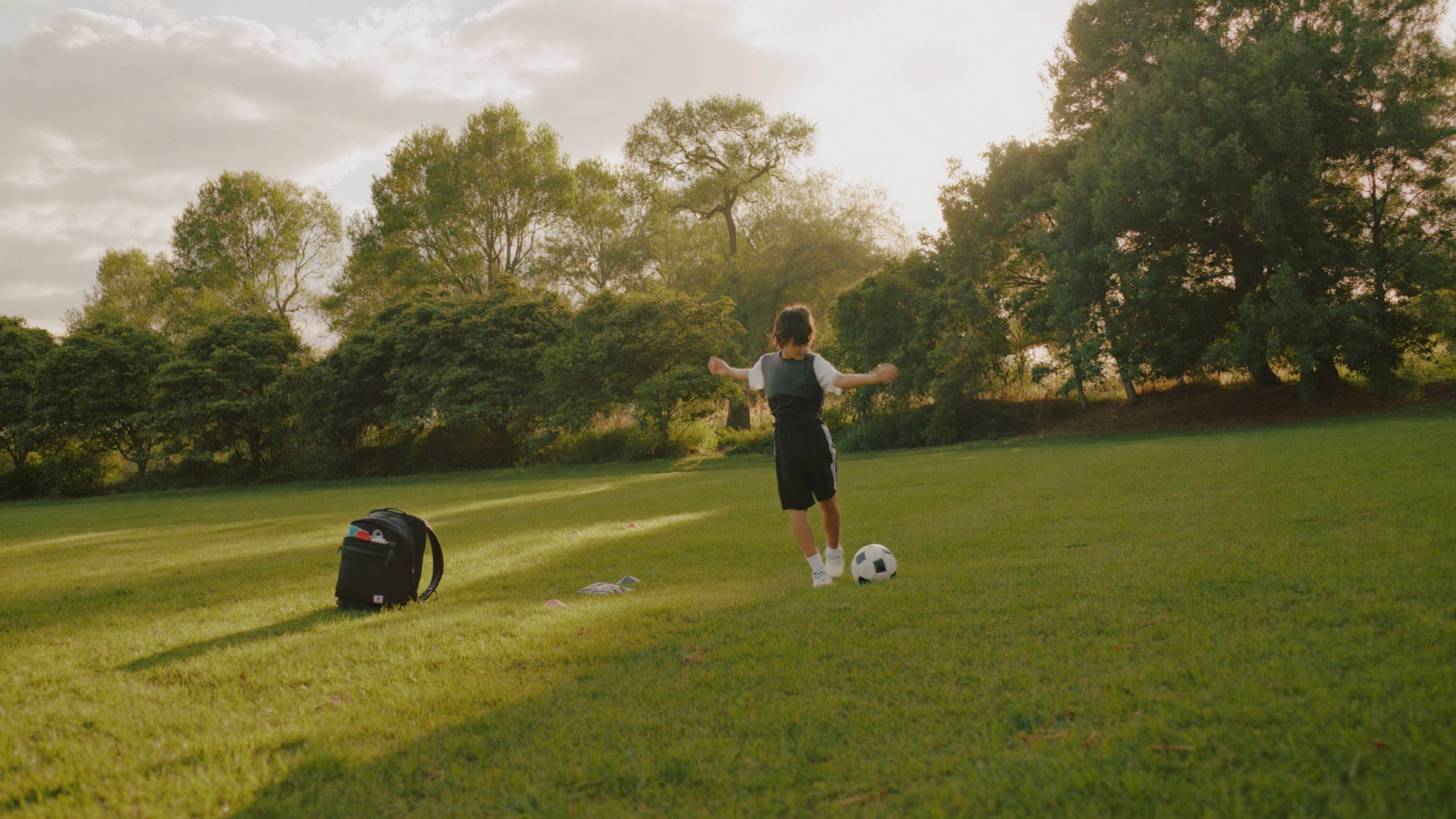 Young player training after school on a Mount Pleasant field with a backpack on the sideline