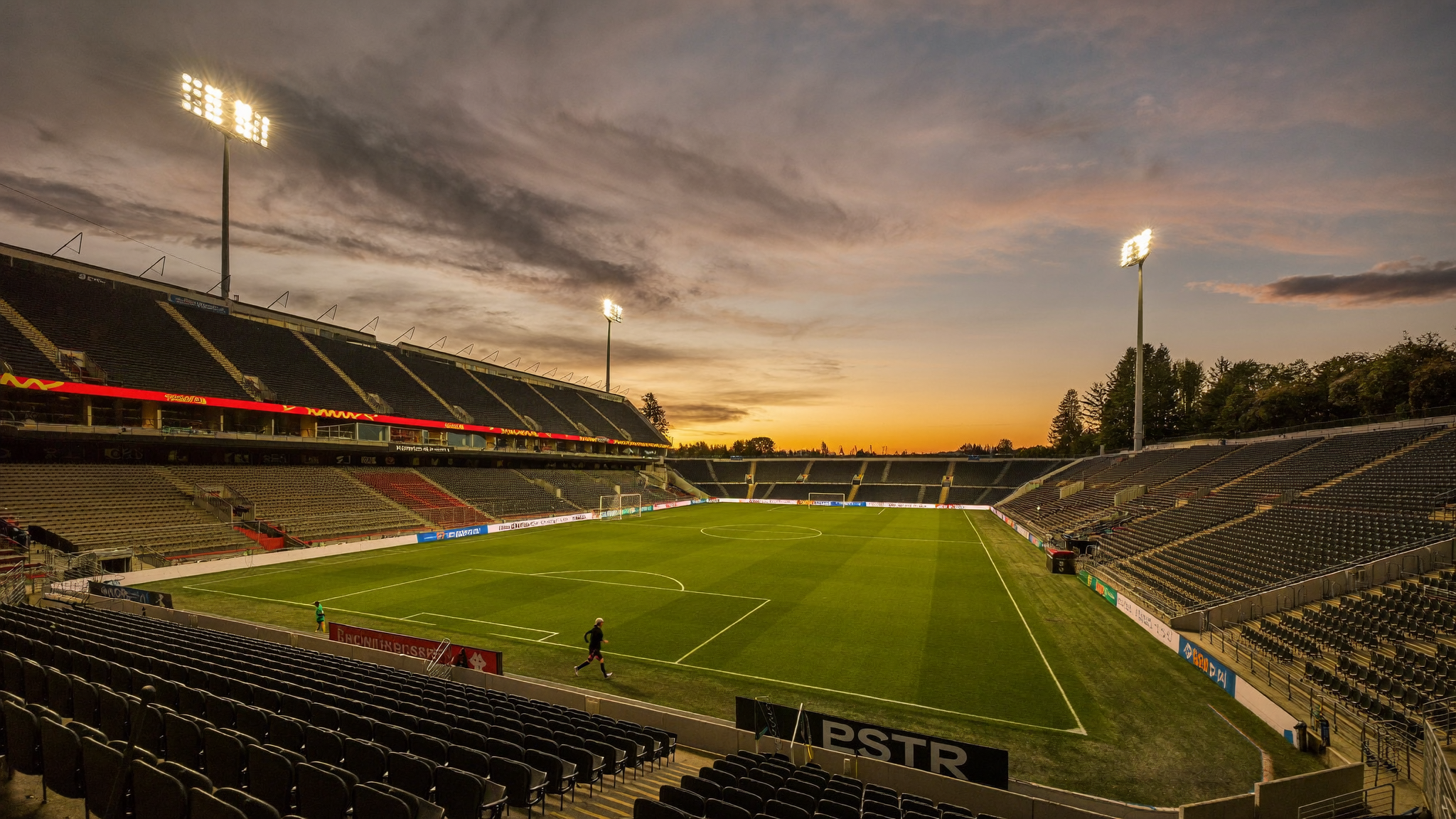 Professional soccer stadium at dusk with floodlights on an empty pitch in Charleston
