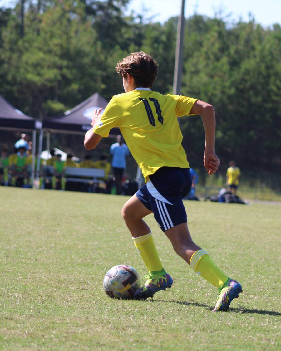 Olly on the ball in a yellow number 11 kit